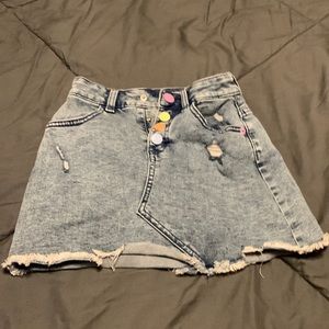 Denim skirts with rainbow pastel buttons.